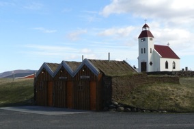 Village de KELDUR avec son poste à essence, son église et ses fermes aux toits de tourbe Village de KELDUR avec son poste à essence, son église et ses fermes aux toits de tourbe